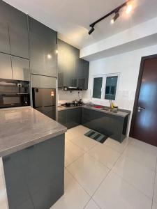 a large kitchen with stainless steel appliances and gray cabinets at Mont kiara Warmly Home A-29-06 in Kuala Lumpur