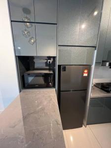 a small kitchen with a stainless steel refrigerator at Mont kiara Warmly Home A-29-06 in Kuala Lumpur