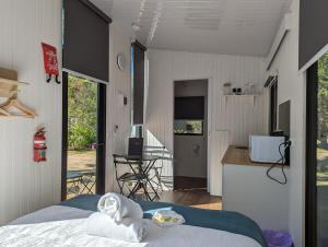 a bedroom with a bed and a kitchen with a counter at Tiny House 14 at Grampians Edge in Dadswells Bridge