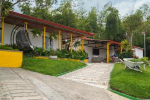 a house with a wheelbarrow in front of it at Alto Bonito Campestre in Circasia
