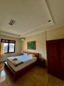 a bedroom with a bed and a window at Nua House in Ubud