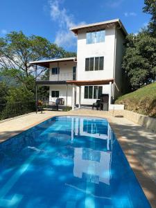 een huis met een blauw zwembad ervoor bij Finca en San Jerónimo, todas las comodidades in San Jerónimo