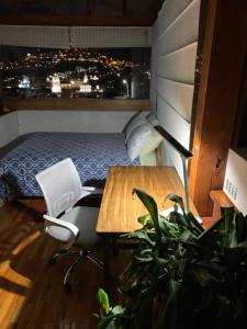 a bedroom with a bed and a desk and a table at Quito Downtown View Point Studio in Quito