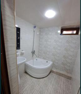 y baño con bañera, aseo y lavamanos. en Guesthouse Anora en Samarcanda