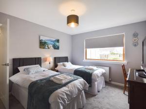 a bedroom with two beds and a window at Fircroft in Glencarse
