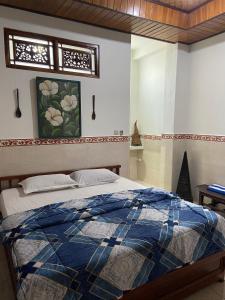 a bedroom with a bed with a blue comforter at Bagus Homestay in Padangbai