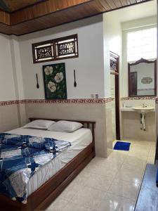 a bedroom with a bed and a sink at Bagus Homestay in Padangbai