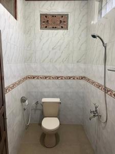 a bathroom with a toilet and a shower at Bagus Homestay in Padangbai