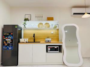 a kitchen with a white counter and a black refrigerator at Vinhomes Grand Park - FEBRUARYroom in Gò Công