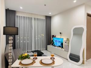 a living room with a table and a tv at Vinhomes Grand Park - FEBRUARYroom in Gò Công