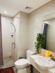 a bathroom with a toilet and a sink and a shower at Vinhomes Grand Park - FEBRUARYroom in Gò Công