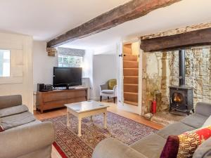 uma sala de estar com um sofá e uma lareira em Jasmine Cottage em Osmington