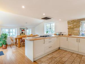 a kitchen with white cabinets and a counter top at Jasmine Cottage in Osmington