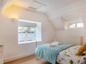 a bedroom with a bed and a window at Jasmine Cottage in Osmington