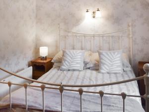 a bedroom with a white bed with white sheets and pillows at Bayview in Kentallen