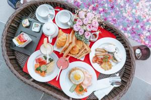 a table with plates of food on a table with roses at One Bedroom Private Villa Kuta in Seminyak