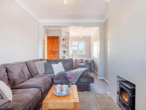 a living room with a couch and a fireplace at Capston Cottage in Langton Matravers