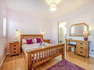 a bedroom with a large bed and a mirror at Capston Cottage in Langton Matravers