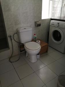 a bathroom with a toilet and a washing machine at Les Filaos De Pereybere in Pereybere