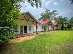 a row of cottages in a field with trees at Chaikoni Lodge in Pucallpa