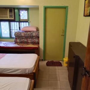 um quarto com três camas e uma porta verde em WISHTREE DORMITORY/CORPORATE DORMITORY FOR TECHIES AND TRAINEES em Chennai