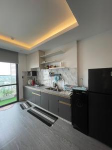 a kitchen with a black refrigerator and a sink at Căn hộ 2 phòng ngủ tầng 17 Sophia Center in Ấp Rạch Mẹo