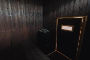 een donkere kamer met een deur en een vuilnisbak bij 6ishiki in Kameoka