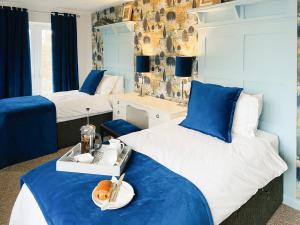 North End Cottage في Longframlington: غرفة نوم بسريرين باللونين الأزرق والأبيض
