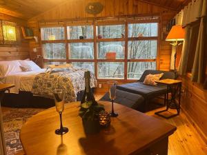 um quarto com uma cama e uma mesa com copos de vinho em Private Mtn Love Shack w/ fast wifi, BBQ & view em Franklin