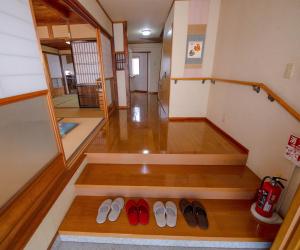 una stanza con un mucchio di scarpe sul pavimento di 忠大　 a Ōbe
