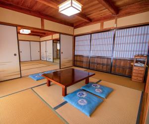 a large room with a table and two blue mats at 忠大　 in Ōbe
