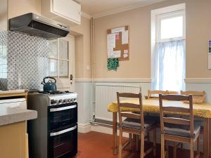 a kitchen with a stove and a table with chairs at River View in Youlgreave