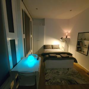 a bedroom with a bed and a table with a blue light at London Oasis Studio Apartment in London