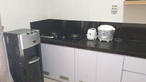 una cucina con piano di lavoro nero e apparecchio di Vila Adinda Syariah C-4 Bukit Gardenia Resort a Garut