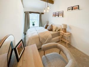 um quarto com uma cama e uma mesa com uma cadeira em Middle Cottage em Middlesmoor