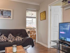 a living room with a couch and a television at Wyndham House in Troed-y-rhiw