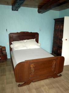 a wooden bed with white sheets and a wooden dresser at Maison de 3 chambres avec jardin amenage a Sibiril a 3 km de la plage in Sibiril