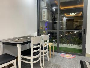 ein Esszimmer mit einem Tisch, Stühlen und einem Fenster in der Unterkunft Căn hộ 2 phòng ngủ tầng 17 Sophia Center in Ấp Rạch Mẹo