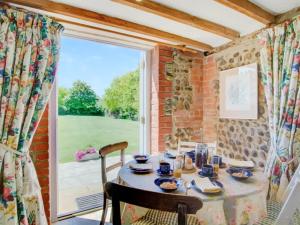 a dining room with a table and a large window at The Gig House in Witton