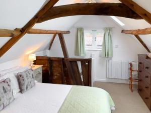 a bedroom with a white bed and wooden beams at The Gig House in Witton