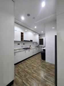 a large kitchen with white cabinets and a wooden floor at Samuel Court in Abuja