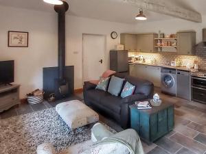 a living room with a couch and a stove at Pippin - Uk37379 in Pilton