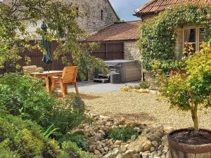 a patio with a table and a grill in a yard at Pippin - Uk37379 in Pilton