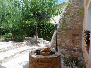 un jardín con una maceta de flores en una pared de piedra en Clos Mazerolles, en Cruzy