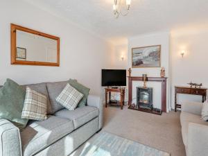 a living room with a couch and a fireplace at Goose Green House in Sutton Bridge