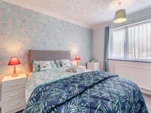 a bedroom with a bed with a blue blanket at Goose Green House in Sutton Bridge