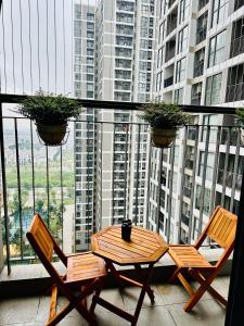 2 sillas y mesa en un balcón con vistas en Xjng Homes - Ocean Park, en Hanói