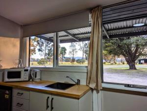 a kitchen with a window and a sink and a microwave at The Peaks 2 in Dadswells Bridge