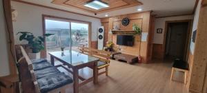 sala de estar con mesa y sofá en 나무집 게스트하우스 en Jeju