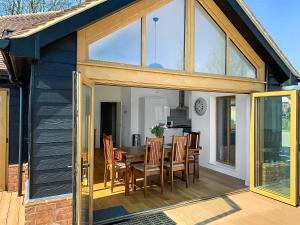 una extensión a una casa con mesa y sillas en Chestnut Lodge en Langley